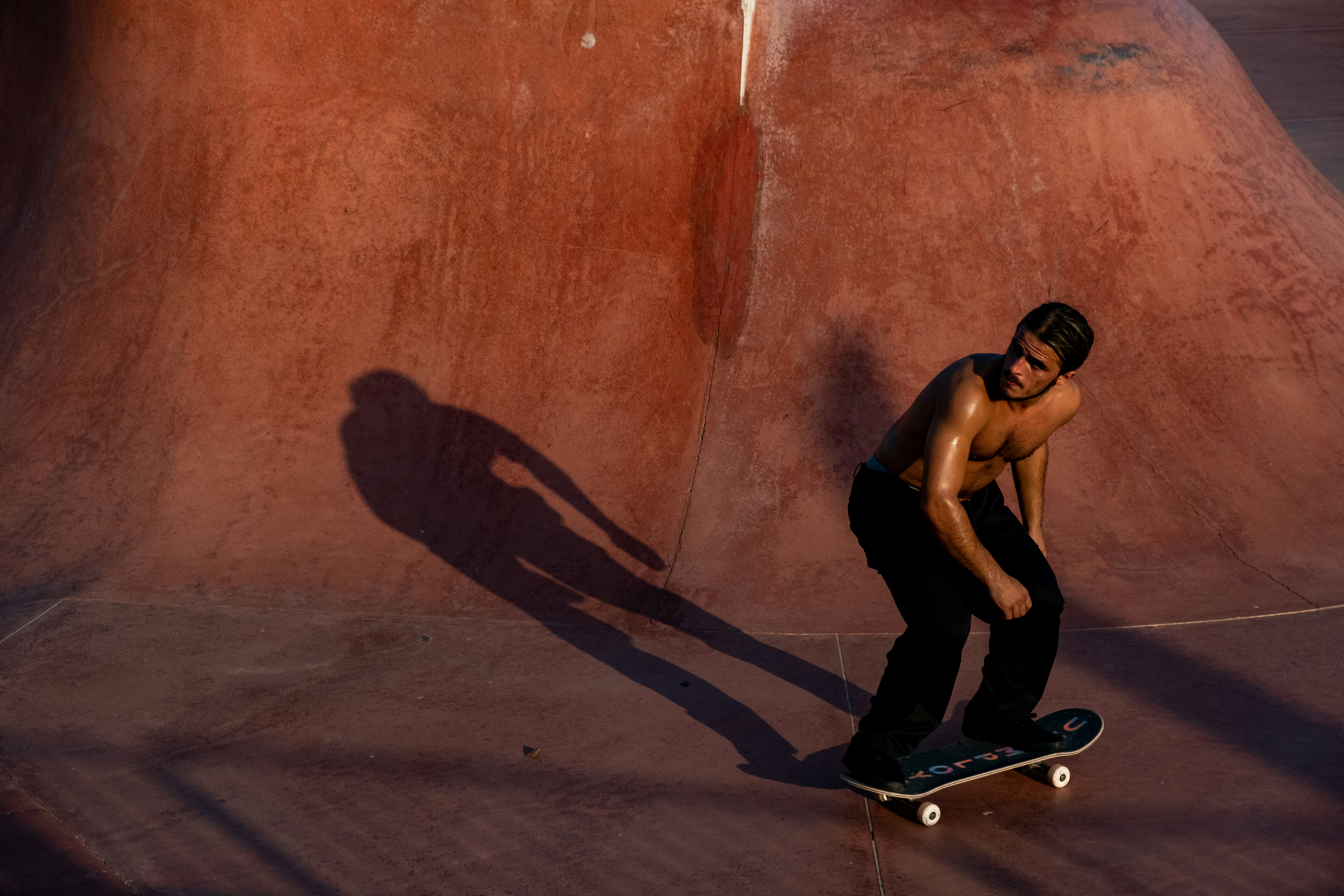 topless man skating on brown ramp